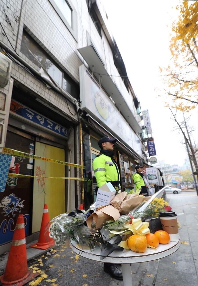 . 지난 11일 화재로 7명이 사망한 종로구 국일고시원 앞 탁자 위에 시민들의 추모 꽃 등이 놓여 있다. 연합뉴스