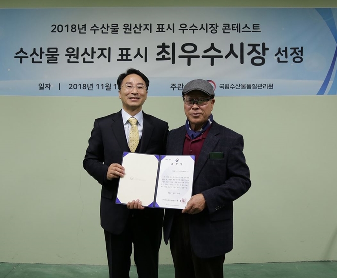 우동식(왼쪽) 국립수산물품질관리원장이 13일 대전 노은시장에서 현종섭 ㈜대전노은진영수산 대표에게 ‘2018년 수산물 원산지 표시 우수시장 콘테스트’ 최우수상을 수여했다. 대전시 제공