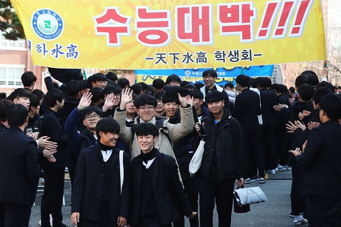 대학수학능력시험을 이틀 앞둔 13일 오후 경기도 수원시 팔달구 수원고등학교에서 3학년 학생들이 후배들의 응원을 받으며 학교를 나서고 있다. 연합뉴스