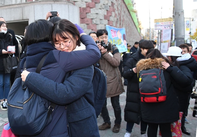 지진으로 수능이 일주일 연기됐던 지난해 11월 23일 오전 포항 이동중학교 고사장 앞에서 수험생들이 입실을 앞두고 포옹하고 있다. 한국일보 자료사진