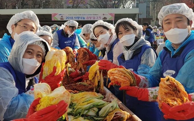 삼성전기 임직원들이 14일 경기 수원시 영통구 수원종합자원봉사센터에서 이웃들과 나눌 김치를 버무리고 있다. 삼성전기 제공