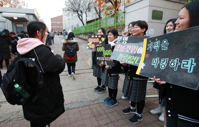 2019학년도 대학수학능력시험일인 15일 서울 개포고등학교 앞에서 수험생이 후배들의 격려를 받고 있다. 연합뉴스