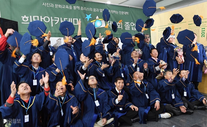 사진전문학교 '희망아카데미' 3기 과정을 마친 노숙인들이 15일 중구 세종대로 시청에서 열린 졸업식에서 ‘사각모’를 던지며 즐거워하고 있다. 배우한 기자