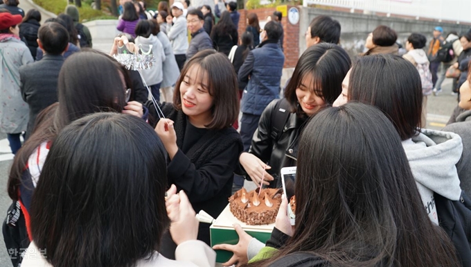 2019학년도 대학수학능력시험일인 15일 오후 경북 포항 유성여고에서 재수를 한 어느 수험생이 장미꽃과 케이크를 들고 기다리던 친구들의 축하를 받고 눈물을 흘리고 있다. 포항=김정혜기자 kjh@hankookilbo.com