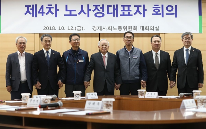 지난달 12일 서울 새문안로 S타워에서 열린 제4차 노사정대표자 회의에서 노사정 참석자들이 손을 잡고 기념사진을 찍고 있다. 연합뉴스