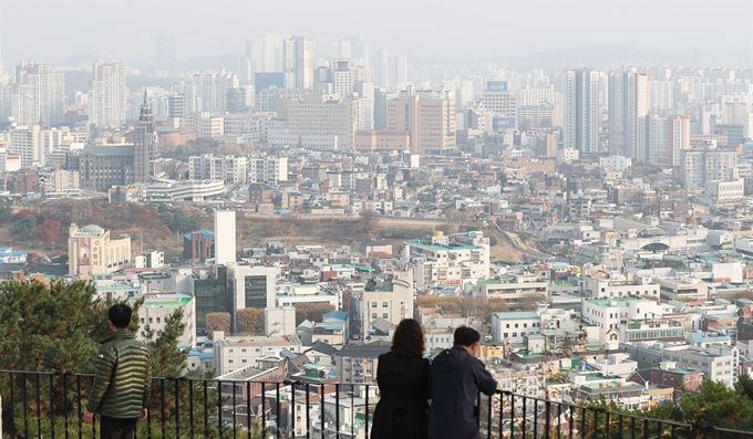 16일 오후 경기도 수원시 서장대에서 시민들이 미세먼지로 뿌옇게 보이는 시내를 바라보고 있다. 연합뉴스