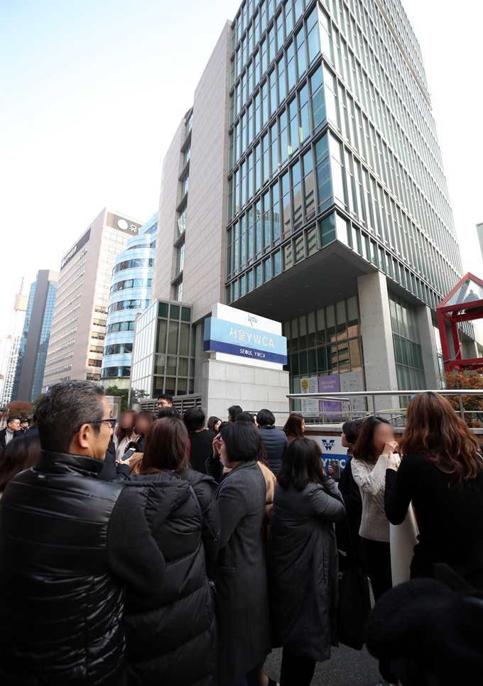 19일 오전 9시 42분께 서울 중구 명동 서울YWCA회관 지하 1층 수영장 공사장에서 화재가 발생해 건물 안에 있던 시민들이 대피하고 있다. 연합뉴스