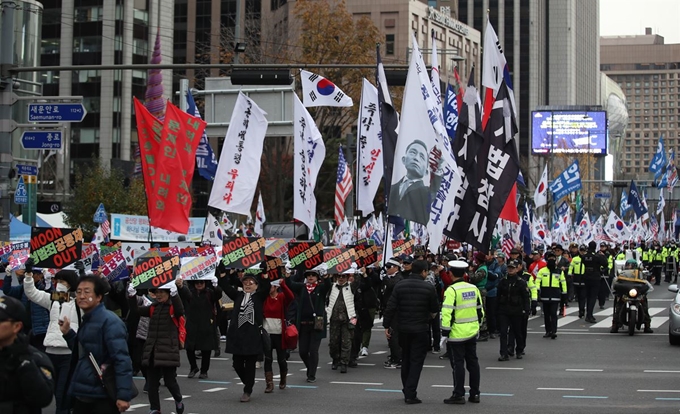 지난 17일 서울 광화문 네거리에서 대한애국당 관계자들이 태극기 집회를 갖고 행진을 하고 있다. /뉴시스