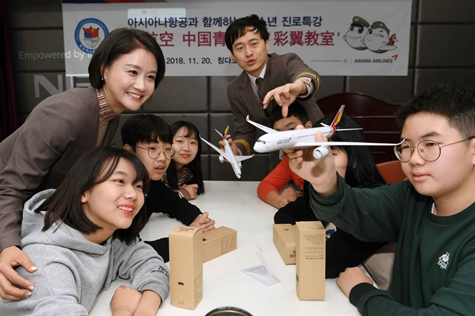 아시아나항공이 20일 중국 칭다오 소재 '칭다오 청운한국학교'에서 실시한 6차 해외 색동나래교실에서 임직원 강사와 참가자가 종이 비행기를 날리며 기념 촬영을 하고 있다. 아시아나 제공