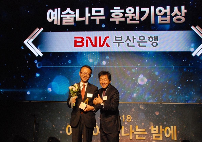 BNK부산은행은 20일 오후 서울 잠실 롯데타워 시그니엘호텔에서 열린 ‘2018 예술이 빛나는 밤에’ 시상식에서 지역 문화예술발전에 공헌한 점을 인정받아 6년 연속 ‘예술나무 후원기업상’을 수상했다. (사진 왼쪽부터 부산은행 김해수 자금증권부 부장, 한국문화예술위원회 유인택 위원)