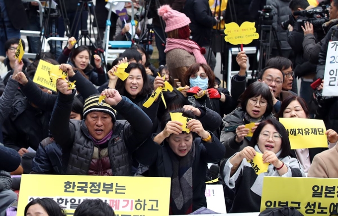 정부가 화해치유재단을 해산한다고 공식 발표한 21일 서울 종로구 옛 일본대사관 앞에서 열린 일본군 위안부 문제 해결을 위한 정기 수요시위 참가자들이 '2015 한일합의' '화해치유재단'이라고 적힌 종이를 찢고 있다. 연합뉴스