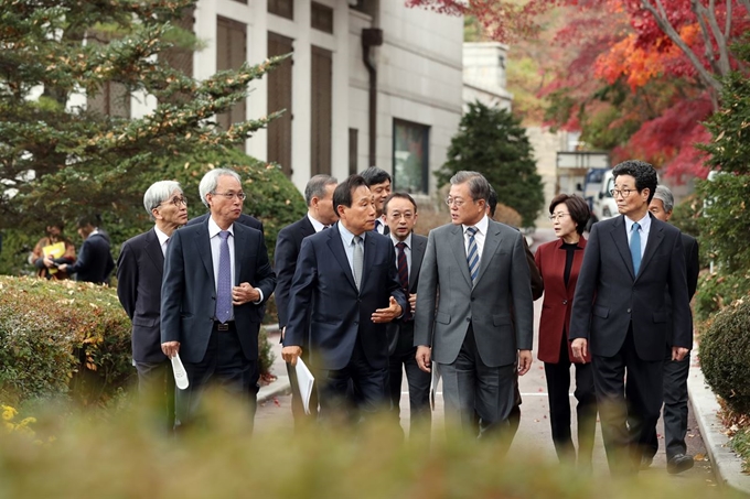 문재인 대통령이 21일 오전 청와대 본관 집현실에서 열린 '국정과제위원회 및 대통령자문위원회 오찬간담회’를 마친 후 참석자들과 경내를 산책하고 있다. 류효진 기자