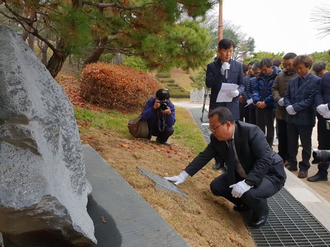 박연수 전 직지원정대장이 21일 충북지역 산악인들이 묵념을 하는 가운데 박종성·민준영 대원을 기리는 추모조형물과 추모비를 매만지고 있다. 한덕동 기자