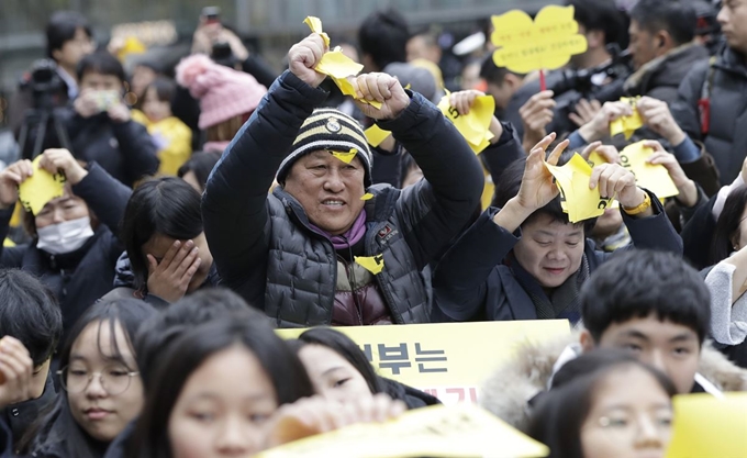 서울 일본 대사관 부근에서 일본군 위안부 문제 해결을 위한 정기 수요시위가 열린 21일 참가자들이 '2015 한일 합의 및 화해치유재단'이라고 적힌 종이를 찢고 있다. 정부는 이날 화해치유재단을 해산한다고 공식 발표했다. AP 연합뉴스