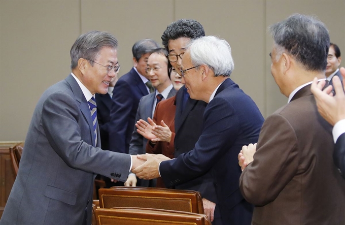 문재인 대통령이 21일 오전 청와대에서 정책기획위원회를 비롯한 국정과제를 추진하는 직속기구 및 대통령 자문기구 위원들과 오찬 간담회에 입장하며 문성현 경제사회노동위원회 위원장과 인사를 나누고 있다. 연합뉴스