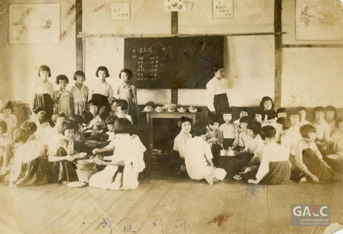 '2018년 옛 사진 공모전'에서 수상한 시민 출품 사진. 1950년대에 어머니가 학교에서 가정실습으로 튀김요리를 배우는 모습이다. 교실 벽에는 지도와 애국가, '남을 위하자'는 교훈, '참다운 여성이 되자'라는 급훈도 눈에 띈다. 경북기록문화연구원 제공