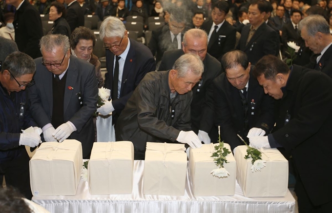 22일 제주4·3평화공원 평화교육센터에서 열린 '4·3 희생자 발굴 유해 신원확인 보고회'에서 유족들이 가족 유해에 이름표를 붙이고 있다. 연합뉴스