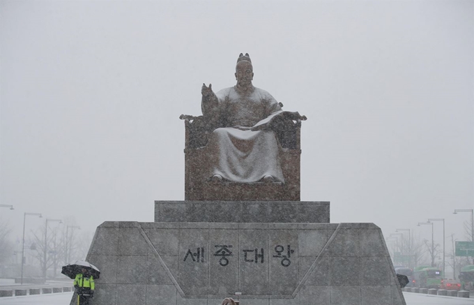 24일 오전 서울 종로구 광화문광장 세종대왕 동상에 첫눈이 내리고 있다. 연합뉴스