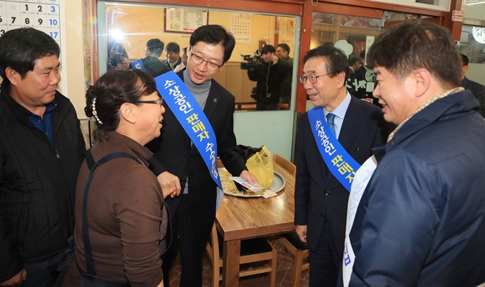 김경수 경남지사와 박원순 서울시장이 24일 경남 창원 상남시장에서 상인들에게 ‘제로페이’ 가입 혜택을 소개하는 현장캠페인을 펼치고 있다. 경남도 제공