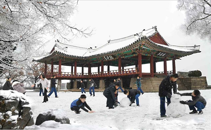 북한 평양에도 첫눈이 내렸다고 노동당 기관지 노동신문이 25일 전했다. 사진은 흰 눈으로 덮인 평양 련광정 앞에서 눈사람을 만들며 뛰어노는 북한 어린이들의 모습. 연합뉴스