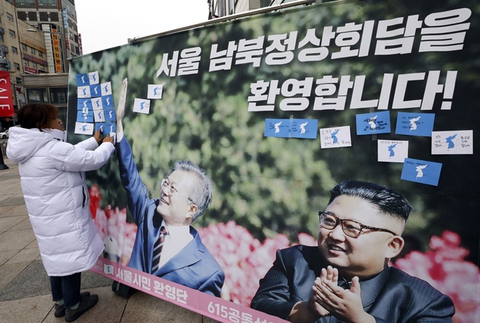 21일 오후 서울 노원구 롯데백화점 앞에서 열린 '서울 남북 정상 회담 성사, 김정은 국무위원장 환영 노원시민환영단 발족 기자회견'에서 노원시민환영단 회원이 환영 메시지가 적힌 한반도 메모지를 붙이고 있다. 뉴시스