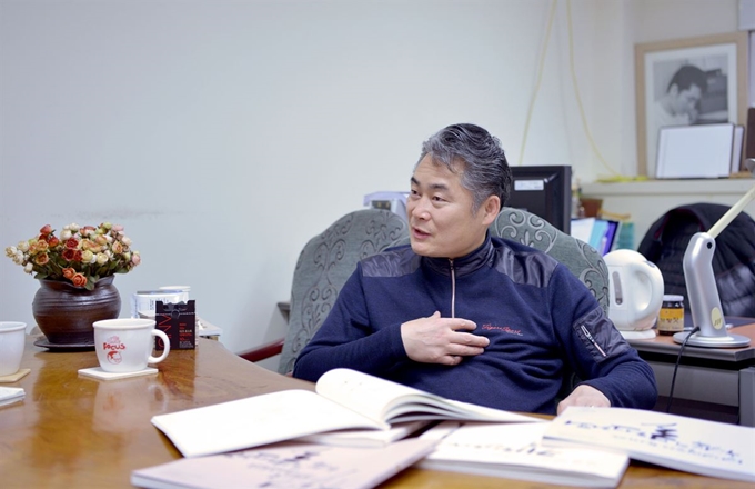 김상돈 교수가 27일 경민대 교수 연구실에서 캘리그라피 매력에 대해 이야기하고 있다. 그의 연구실 책상 위에 자신이 만든 캘리그라피 교재가 놓여 있다. 고광준 교수 제공