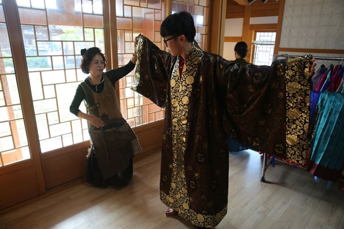 지난 8월 롯데면세점의 ‘글로벌 앰버서더’ 한국문화탐방 프로그램에 참가한 외국인 유학생이 백제의 전통의상을 입어보고 있다. 롯데면세점 제공