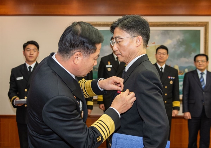 3일 해군 재경근무지원대대에서 열린 아주대학교 권역외상센터장 이국종 교수 명예해군 중령 임명식에서 심승섭 해군참모총장(왼쪽)이 이국종 교수에게 항공휘장을 수여하고 있다. 연합뉴스