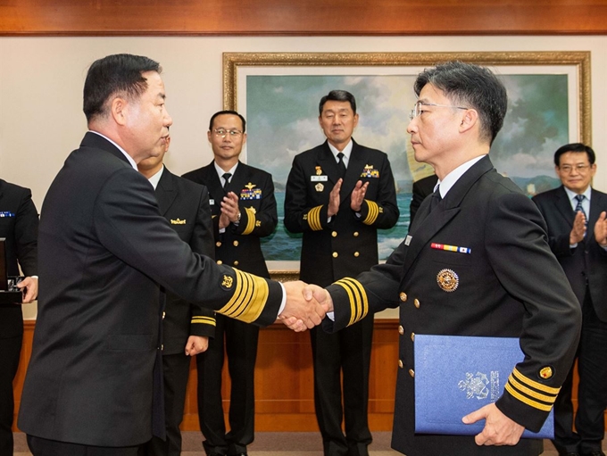 3일 서울 해군 재경근무지원대대에서 열린 아주대학교 권역외상센터장 이국종 교수 명예해군 중령 임명식에서 심승섭 해군참모총장(왼쪽)이 이국종 교수에게 명예해군 중령 임명장을 수여한 뒤 악수하고 있다. 뉴시스