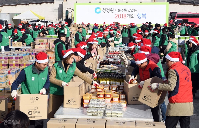 5일 오전 서울 광화문 북측광장에서 열린 '청정원 나눌수록 맛있는 2018개의 행복' 나눔행사에서 대상(주) 임정배(왼쪽) 대표이사를 비롯한 청정원 광고모델 배우 김성령(왼쪽 두번째), 주부봉사단 등이 어려운 이웃들에게 전달할 식료품 나눔박스를 포장 하고 있다. 신상순 선임기자