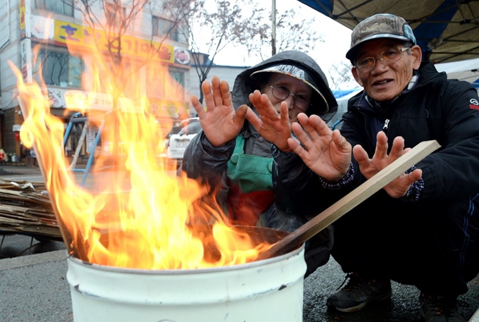 전북 전주시의 체감온도가 영하 1도까지 내려가는 등 강추위가 시작되면서 차가운 겨울 날씨를 보인 6일 완산구 남부시장에서 상인들이 모닥불을 쬐며 추위를 녹이고 있다. 전주=뉴시스