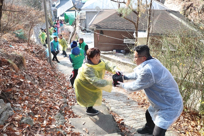 6일 서울 강북구 일대에서 자원봉사자들이 소외된 이웃에 전달할 연탄을 나르고 있다. 사진=강북구 제공