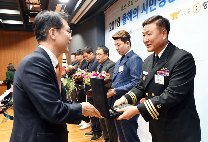 13일 서울 마포구 에쓰오일 본사에서 열린 ‘올해의 시민영웅’ 시상식에서 류열(왼쪽) 에쓰오일 사장이 김용우 해군 중령 등 수상자들에게 표창장과 상금을 건네고 있다. 에쓰오일 제공