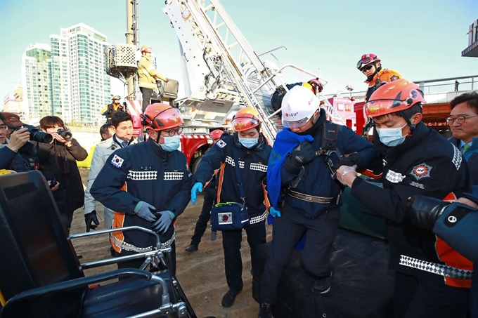 14일 오후 서울 용산구 한강대교 북단 LG유플러스 본사 인근 철탑에서 고공농성을 해제한 고진복 서산지회 조직차장이 고공농성을 해제한 뒤 근처에서 대기 중이던 소방대원들에게 부축받고 있다. 연합뉴스