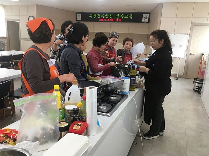 괴산 장수밥상집 주인들이 괴산군농업기술센터에서 옥수수 비빔밥 등 새로 개발된 음식 조리법을 배우고 있다. 괴산군 제공