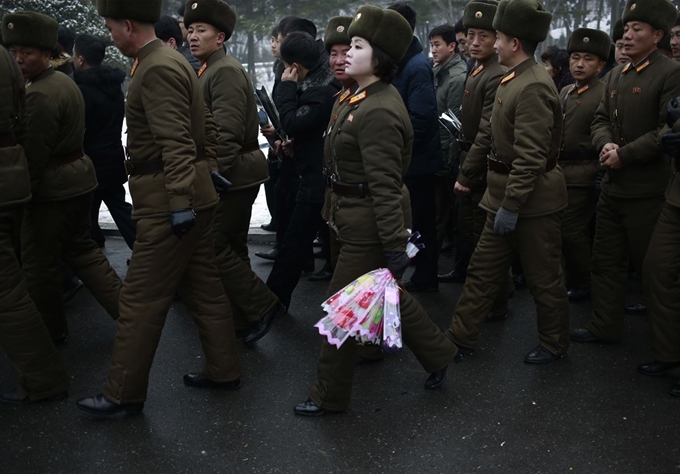 김정일 7주기를 맞은 북한 군인이 김일성, 김정일 동상 앞에 놓을 꽃을 들고 순서를 기다리고 있다. 연합뉴스