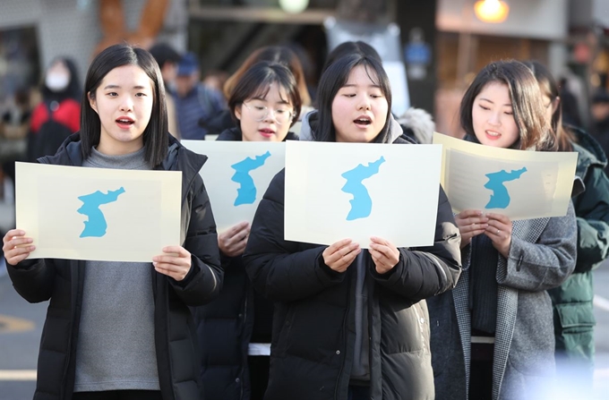 지난 1일 서울 마포구 서교동 홍대입구 걷고싶은거리에서 열린 남북정상회담 성공기원 합창 퍼포먼스에서 참가자들이 한반도기를 들고 합창하고 있다. 연합뉴스