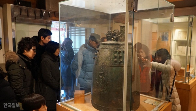 [저작권 한국일보]포항 시티투어 이용객들이 포항 남구 오천읍 오어사내 유물전시관에서 해설사의 설명을 들으며 사찰 인근에서 발견된 동종을 살펴보고 있다. 포항=김정혜기자 kjh@hankookilbo.com