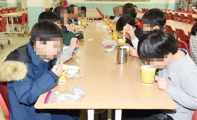 전국학교비정규직 노동조합 울산지부가 총파업에 돌입한 19일 오후 학교 급식이 중단되자 울산시 중구 태화초등학교 3학년 학생들이 점심으로 라면을 먹고 있다. 뉴시스