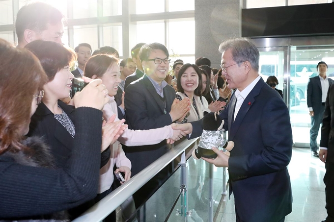 문재인 대통령이 20일 오전 2019 국방부 업무보고를 우해 서울 용산 국방부에 도착한 뒤 직원들의 선물을 받은 뒤 악수하고 있다. 연합뉴스