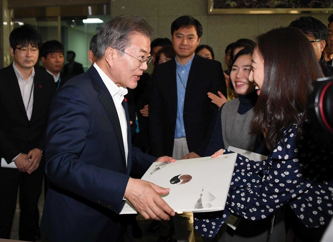 문재인 대통령이 20일 오전 서울 용산 국방부에서 열린 2019 업무보고를 마친 뒤 국방부 직원들을 격려하다 2019년 국방부 달력을 선물받고 있다. 연합뉴스