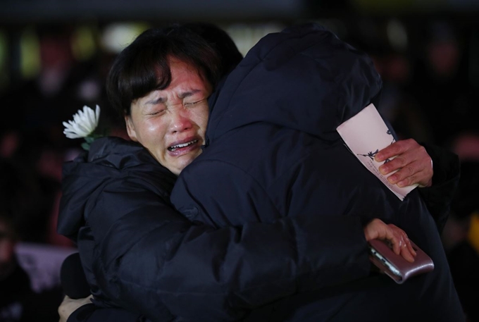 19일 오후 서울 종로구 광화문광장에서 열린 태안화력 비정규직 청년노동자 고 김용균 3차 촛불 추모제 '청년 추모의 날'에서 김용균 씨의 어머니가 어머니께 드리는 편지를 낭독하던 김재근 청년전태일 대표를 안아주고 있다. 연합뉴스