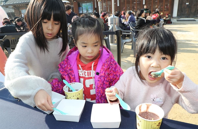 22일 동지를 맞아 열린 서울 남산골한옥마을 세시절기행사 '동지첨치'에 참가한 어린이들이 팥죽을 먹어보고 있다. 연합뉴스