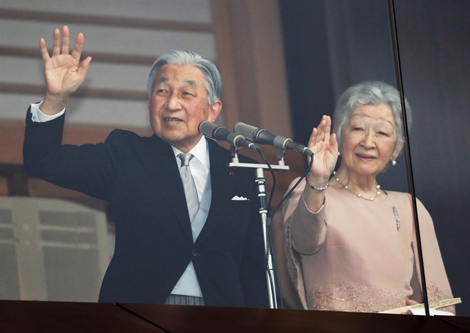 아키히토 일왕 내외가 23일 자신의 85회 생일을 맞아 고쿄에 모인 시민들을 향해 손을 흔들어 답하고 있다. 도쿄=로이터 연합뉴스