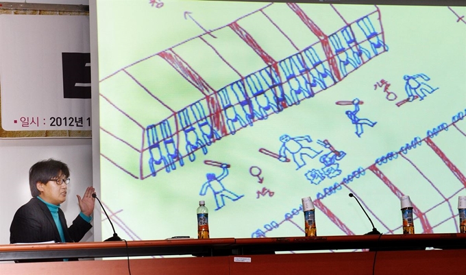 2012년 11월 27일 국회 의원회관에서 열린 형제복지원 사건 피해자 '살아남은 아이 발간보고회'에서 공저자이며 생존자인 한종선씨가 형제복지원의 폭력적인 상황을 그린 그림을 설명하고 있다. 신상순 선임기자 ssshin@hankookilbo.com