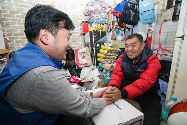 삼성전자 직원이 지난 5일 서울 동대문구에 위치한 쪽방에 거주하는 어르신을 방문해 생필품 세트를 전달하고 안부를 묻고 있다.