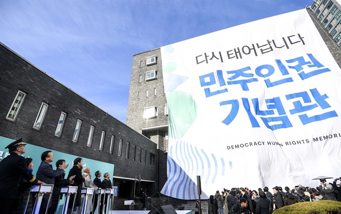 26일 서울 남영동 경찰청인권보호센터(옛 남영동 대공분실)에서 열린 '옛 남영동 대공분실 이관행사'에서 참석인사들이 버튼을 누르자 현수막이 내려와 건물을 덮고 있다.남영동 대공분실은 고 김근태 전 민주통합당 상임고문, 박종철 열사 등 수많은 민주화 인사들이 고문을 받은 곳이다. 정부는 이 자리에 2022년 '민주인권기념관'을 건립할 계획이다. 뉴스1