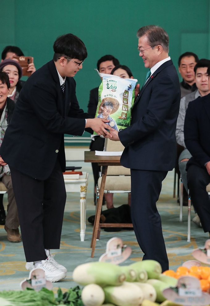 문재인 대통령이 27일 오전 청와대 영빈관에서 '밥상이 힘이다'라는 주제로 열린 농업인 초청 간담회에서 중학생 농부인 한태웅 군(15)이 직접 수확한 쌀 5kg을 전달받고 있다. 한 군은 경기도 안성에서 할아버지를 도와 직접 농사에 참여해 이 쌀을 수확했다. 한 군의 취미는 농사와 트로트 부르기, 장래희망은 대농(大農)이다. 연합뉴스