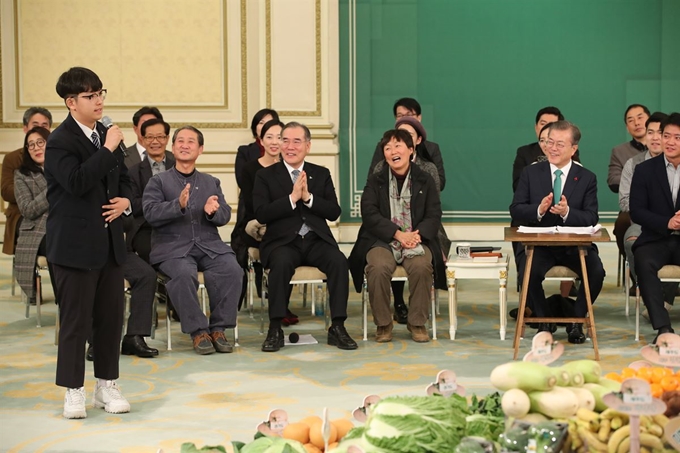 중학생 농부인 한태웅 군(15)이 27일 오전 청와대 영빈관에서 '밥상이 힘이다'라는 주제로 열린 농업인 초청 간담회에서 직접 수확한 쌀 5kg을 문재인 대통령에게 전달한 뒤 트로트 '흙에 살리라'를 열창하고 있다. 연합뉴스