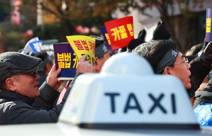 지난 14일 서울개인택시조합 소속 택시 운전기사들이 서울 여의도 더불어민주당사 앞에서 카풀 규탄 생존권 사수 결의대회를 열고 있다. 연합뉴스